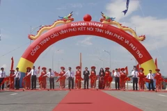 Lãnh đạo hai tỉnh Vĩnh Phúc và Phú Thọ cùng các đại biểu cắt băng khánh thành cầu Vĩnh Phú. (Ảnh: Hoàng Hùng/TTXVN)
