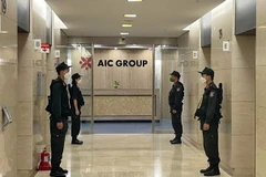 Lực lượng Cảnh sát điều tra làm nhiệm bảo vệ trong quá trình khám xét tại trụ sở Công ty AIC, 69 phố Tuệ Tĩnh, ngày 29/4/2022. (Ảnh: Phạm Kiên/TTXVN)