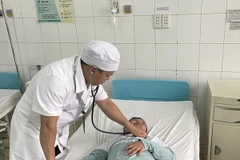 Bệnh nhi N.Đ.K. được bác sỹ Bệnh viện Nhi đồng Đồng Nai kiểm tra sức khỏe sau ca phẫu thuật. (Ảnh: Lê Xuân/TTXVN)