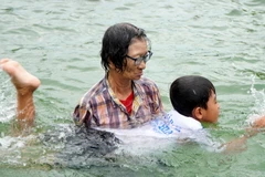 Bà Trần Thị Kim Thia dạy cho trẻ động tác bơi. (Ảnh: Nhựt An/TTXVN)