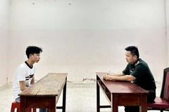 Chiến sỹ Đồn Biên phòng Cửa khẩu quốc tế Mộc Bài lấy lời khai ban đầu đối tượng Hà Huy Mạnh để xác minh, lấy lời khai, củng cố hồ sơ. (Ảnh: TTXVN phát)
