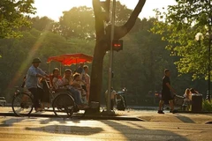 Du khách trải nghiệm du lịch quanh hồ Hoàn Kiếm bằng xích lô. (Ảnh: Khánh Hòa/TTXVN)