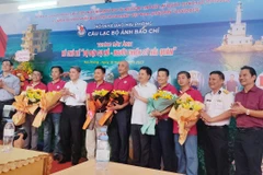 Đại diện Ban Tuyên giáo Thành ủy, Hội Nhà báo Hải Phòng tặng hoa cho các nghệ sỹ nhiếp ảnh có tác phẩm trưng bày. (Ảnh Minh Huệ/TTXVN)