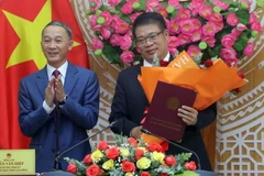 Ông Trần Văn Hiệp, Chủ tịch UBND tỉnh Lâm Đồng trao Quyết định của Thủ tướng Chính phủ cho ông Nguyễn Ngọc Phúc. (Ảnh: Chu Quốc Hùng/TTXVN)