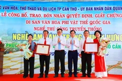 Đại diện lãnh đạo UBND thành phố Cần Thơ trao quyết định Di sản Văn hóa phi Vật thể Quốc gia Làng nghề làm bánh tráng Thuận Hưng cho đại diện chính quyền địa phương. (Ảnh: TTXVN phát)