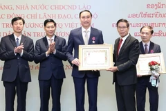 Ủy viên Bộ Chính trị Đảng Nhân dân Cách mạng Lào, Chủ tịch Ủy ban Trung ương Mặt trận Lào xây dựng đất nước Sinlavong Khoutphaythoune trao tặng Huân chương Itxala cho ông Phùng Khánh Tài nguyên Phó Chủ tịch Ủy ban Trung ương MTTQ Việt Nam, Phó Bí thư Thườ