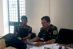 Cán bộ Đồn Biên phòng cửa khẩu quốc tế Mộc Bài lấy lời khai đối tượng Nguyễn Thành Trung. (Nguồn: Biên Phòng)