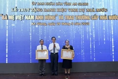 Thừa ủy quyền của Chủ tịch nước, ông Lê Hồng Quang, Bí thư Tỉnh ủy An Giang trao Bằng vinh dự truy tặng Danh hiệu “Bà mẹ Việt Nam Anh hùng” cho thân nhân mẹ Lâm Thị Chính và mẹ Mai Thị Măng. (Ảnh: Thanh Sang/TTXVN)