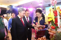 Ông Đặng Minh Thông, Phó Chủ tịch UBND tỉnh tham gia thực hiện nghi thức cột chỉ cổ tay cùng nhau chúc năm mới an khang, thịnh vượng tại ngày hội. (Nguồn: Báo Bà Rịa-Vũng Tàu)