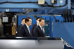 Tổng thống Yoon Suk-yeol và Chủ tịch Tập đoàn SK Chey Tae-won, phải, kiểm tra cơ sở tấm bán dẫn silicon của SK Siltron ở Gumi, tỉnh Bắc Gyeongsang. (Nguồn: Yonhap)