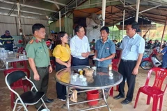 Chủ tịch UBND huyện Bù Đăng Vũ Văn Mười động viên, hỗ trợ gia đình nam thanh niên bị nước lũ cuốn trôi. (Ảnh: Đậu Tất Thành/TTXVN)