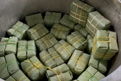 Bánh tét Mặt Trăng và bánh chưng được xếp vào nồi để luộc. (Ảnh: Thanh Thủy/TTXVN)