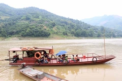 Người dân huyện Mường La, tỉnh Sơn La, sử dụng thuyền tự đóng để chở người và hàng hóa qua hai bên bờ sông. (Ảnh: Hữu Quyết/TTXVN)
