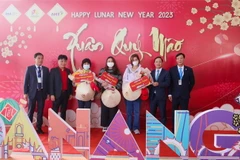 Ban tổ chức tặng hoa và quà cho những du khách quốc tế "xông đất" Đà Nẵng đầu năm mới Quý Mão 2023 bằng đường hàng không. (Ảnh: Trần Lê Lâm/TTXVN)