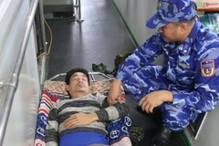 Tổ Quân y, lực lượng Cảnh sát biển sơ cứu ban đầu cho nạn nhân. (Ảnh: TTXVN phát)