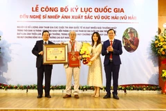 Nguyên Bộ trưởng Bộ Thông tin và Truyền thông, Chủ tịch Hội đồng xác lập Tổ chức Kỷ lục Việt Nam Lê Doãn Hợp trao bằng xác lập kỷ lục và Kỷ niệm chương của Tổ chức Kỷ lục Việt Nam cho nghệ sỹ nhiếp ảnh Vũ Hải. (Nguồn: Báo Vĩnh Phúc)