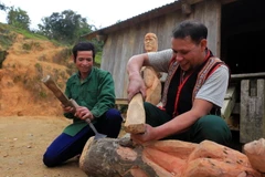 Nghệ nhân ưu tú A Gông (phải) truyền dạy kỹ năng tạc tượng gỗ của người Mơ Nâm cho thanh niên tại làng Kon Du, xã Măng Cành, huyện Kon Plông, tỉnh Kon Tum. (Ảnh: Khoa Chương/TTXVN)