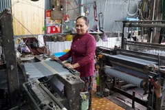 Bà Nguyễn Thị Mèn ngụ xã Long Khánh A, huyện Hồng Ngự, tỉnh Đồng Tháp, có hơn 40 năm theo nghề dệt choàng. (Ảnh: Nhựt An/TTXVN)