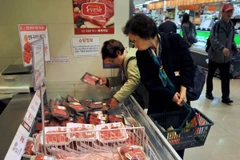 Khách hàng lựa chọn thịt bò. (Ảnh: AFP/TTXVN)
