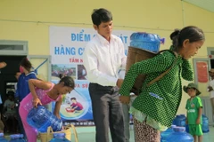 Người dân tại Bình Thuận nhận nước sạch hỗ trợ. (Ảnh: World Vision)