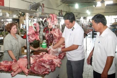 Nhân viên Chi cục thú y kiểm tra các hộ kinh doanh thịt động vật tại chợ ở Long An. (Ảnh: Đình Huệ/TTXVN)