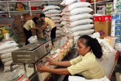 Đóng gói gạo ở Công ty Lương thực Trà Vinh. (Ảnh: Đình Huệ/TTXVN)
