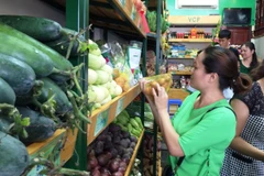 Người tiêu dùng mua hàng tại cửa hàng thực phẩm an toàn của Liên minh hợp tác xã Việt Nam. (Ảnh: Thanh Tâm/Vietnam+)