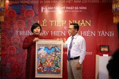 Nhà nghiên cứu, sưu tầm Nguyễn Thị Thu Hòa (trái) trao tặng các hiện vật cho ông Hà Thanh Vân, Giám đốc Bảo tàng Mỹ thuật Đà Nẵng. (Ảnh: Trần Lê Lâm/TTXVN)