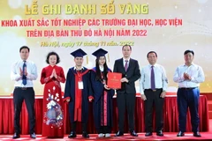 Đại diện Thủ khoa xuất sắc trao lại Sổ vàng cho Phó Bí thư Thành đoàn Hà Nội Nguyễn Tiến Hưng. (Ảnh: Minh Đức/TTXVN)