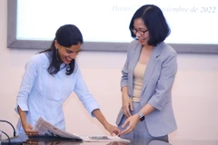 Phó Tổng biên tập Báo Granma (Cuba) Arlin Alberty Loforte giới thiệu một ấn phẩm báo chí của Cuba với Tổng Giám đốc Thông tấn xã Việt Nam Vũ Việt Trang. (Ảnh: Văn Điệp/TTXVN)