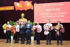 Bí thư Thành ủy Đà Nẵng Nguyễn Văn Quảng (thứ 3 từ trái sang) và Chủ tịch UBND thành phố Đà Nẵng Lê Trung Chinh (thứ 4 từ trái sang) trao quyết định và tặng hoa chúc mừng các cán bộ được điều động, luân chuyển. (Ảnh: Quốc Dũng/TTXVN)