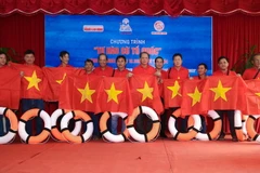 Báo Người Lao Động tặng cờ Tổ quốc cho ngư dân Ninh Thuận. (Ảnh: Công Thử/TTXVN)