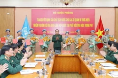 Thượng tướng Phùng Sĩ Tấn trao quyết định cho 4 sỹ quan và chúc mừng 4 sỹ quan đã hoàn thành nhiệm vụ. (Ảnh: Trọng Đức/TTXVN)