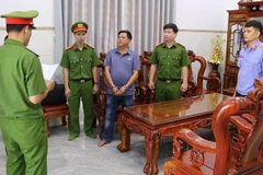 Cơ quan công an đọc lệnh bắt bị can Hoàng Văn Phi. (Ảnh: TTXVN phát)