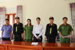 Bị can Nguyễn Thị Hồng Nhung nhận quyết định khởi tố và lệnh bắt tạm giam. (Ảnh: Đinh Thùy/TTXVN)