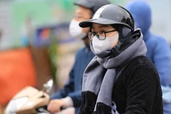 Người dân mặc áo ấm khi ra đường. (Ảnh: Thanh Tùng/TTXVN)