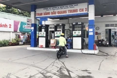Khách hàng đến cửa hàng xăng, dầu trên địa bàn Thành phố Hồ Chí Minh thấy biển "hết xăng" và được nhân viên hướng dẫn đến cửa hàng xăng gần nhất trên cùng địa bàn. (Ảnh: Mỹ Phương/TTXVN)