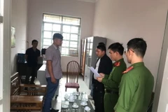 Ông Nông Văn Hoành (bìa trái) nghe đọc quyết định tạm giữ hình sự, điều tra về hành vi Lạm dụng chức vụ quyền hạn chiếm đoạt tài sản. (Ảnh: TTXVN phát)