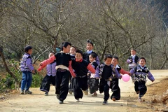 Trẻ em tung tăng đi chơi Tết trong trang phục truyền thống sặc sỡ. (Ảnh: Thanh Hà/TTXVN)