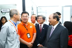 Ông Hoàng Nam Tiến (áo cam) trong một lần Thủ tướng Nguyễn Xuân Phúc tới thăm FPT. (Ảnh: FPT)