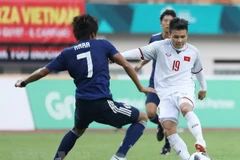 Tiền vệ Quang Hải (áo số 19) trong một pha tranh bóng với cầu thủ đội tuyển Olympic Nhật Bản. (Ảnh: Hoàng Linh/TTXVN) 