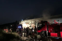 Lực lượng chức năng tiến hành dập lửa tại hiện trường. (Ảnh: Thành Chung/TTXVN)