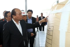 Thủ tướng Nguyễn Xuân Phúc xem sản phẩm của Nhà máy Alumin Nhân Cơ (tỉnh Đắk Nông). (Ảnh: Thống Nhất/TTXVN)