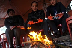 Nhiệt độ xuống thấp, người dân phải đốt lửa sưởi ấm. (Ảnh: Minh Đức/TTXVN)