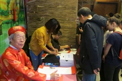Góc thư pháp thu hút nhiều bà con. (Ảnh: Hoàng Linh/Vietnam+)