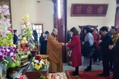 Phát lộc cho các phật tử sau lễ cầu an. (Ảnh: Linh Hương/TTXVN)