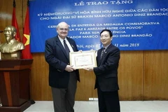 Phó Chủ tịch Liên hiệp các tổ chức hữu nghị Việt Nam Bùi Khắc Sơn trao tặng Kỷ niệm chương Vì hòa bình hữu nghị giữa các dân tộc cho Đại sứ Brazil Marco Antonio Diniz Brandao. (Ảnh: Văn Điệp/TTXVN)