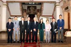 Ông Lê Thanh Liêm (thứ 4 từ trái sang phải) chụp ảnh lưu niệm với ông Ken Kawai (giữa) và các đại biểu. (Ảnh: Xuân Khu/TTXVN)