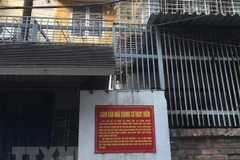 Biển cảnh báo nhà chung cư nguy hiểm tại đơn nguyên 1 và 3, tập thể Bộ Tư pháp. (Ảnh: Minh Nghĩa/TTXVN)