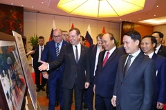 Thủ tướng Liên bang Nga Dmitry Medvedev và Thủ tướng Nguyễn Xuân Phúc tham quan Trưng bày ảnh Việt-Nga: Quan hệ hữu nghị truyền thống và hợp tác toàn diện. (Ảnh: Thống Nhất/TTXVN)